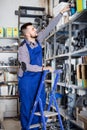 Man worker going through sanitary engineering details in workshop Royalty Free Stock Photo