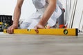 Man worker hands installing timber laminate floor. Precise finishing using spirit level. Wooden floors house renovation