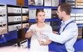 Man worker helping young client girl choosing mailbox in store Royalty Free Stock Photo