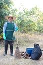 Man worker holds broom ,basket and black garbage bag, equipment to get rid dry leaves in garden. Royalty Free Stock Photo