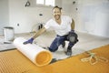 Man worker install orange roll membrane waterproofing on the floor Royalty Free Stock Photo