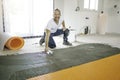 Man worker install orange roll membrane waterproofing on the floor Royalty Free Stock Photo