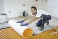 Man worker install orange roll membrane waterproofing on the floor Royalty Free Stock Photo