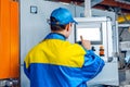 Man worker in manufacturing plant at cable factory machine control computer panel Royalty Free Stock Photo