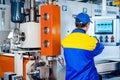 Man worker in manufacturing plant at cable factory machine control computer panel Royalty Free Stock Photo