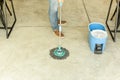 Man worker with mop and bucket cleaning floor in the cafe. Royalty Free Stock Photo