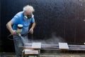 Man worker painting wooden board with spray gun