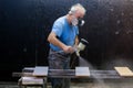 Man worker painting wooden board with spray gun