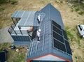 Man worker prepearing for mounting photovoltaic solar modules on roof of house. Royalty Free Stock Photo