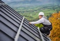 Man worker prepearing for mounting photovoltaic solar modules on roof of house. Royalty Free Stock Photo