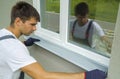 Man worker in protective gloves measuring external frame and PVC window metal sill size Royalty Free Stock Photo