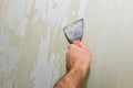 Man worker removing old wallpaper during renovation Royalty Free Stock Photo