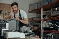 Man worker repair a coffee machine in own workshop and looking camera Royalty Free Stock Photo