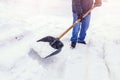 Man worker shovel cleaning snow winter street in front of house after big snowstorm