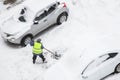 Man, worker shoveling snow after snowfall near car