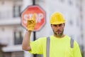 Man in worker uniform and hardhat with open hand doing stop sign with serious and confident expression, defense gesture Royalty Free Stock Photo