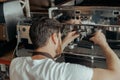 Man worker in uniform inspecting coffee machine in own workshop Royalty Free Stock Photo