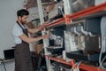 Man worker in uniform inspecting coffee machine in own workshop Royalty Free Stock Photo