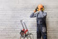 Man worker in uniform is putting his hard hat. Royalty Free Stock Photo