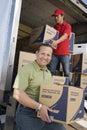 Man With Worker Unloading Truck Of Cardboard Boxes