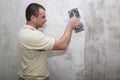 Man worker using float to apply first layer of putty