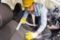 Male using professional steam vacuum for dirty car interior. Professional car cleaning service concept Royalty Free Stock Photo