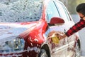 Man worker washing car`s alloy wheels on a car wash Royalty Free Stock Photo