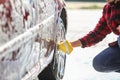 Man worker washing car`s alloy wheels on a car wash Royalty Free Stock Photo