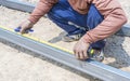 Man workers' hands use measuring tape to measure the length of the steel part in homebuilding. Royalty Free Stock Photo