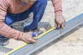 Man workers' hands use measuring tape to measure the length of the steel part in homebuilding. Royalty Free Stock Photo