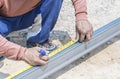 Man workers' hands use measuring tape to measure the length of the steel part in homebuilding. Royalty Free Stock Photo