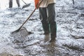 Man workers spreading freshly poured concrete mix