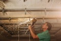 Man is working with an angle grinder and making stretch ceiling. Maintenance repair works renovation in the flat. Restoration Royalty Free Stock Photo