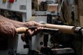 A man in a working apron works on a wood turning lathe. Royalty Free Stock Photo