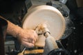 A man in a working apron works on a wood turning lathe Royalty Free Stock Photo