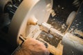 A man in a working apron works on a wood turning lathe Royalty Free Stock Photo