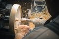 A man in a working apron works on a wood turning lathe Royalty Free Stock Photo