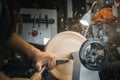 A man in a working apron works on a wood turning lathe Royalty Free Stock Photo