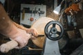 A man in a working apron works on a wood turning lathe Royalty Free Stock Photo