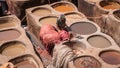 Man working as a tanner in the dye pots at leather tanneries at medina, Fez, Morocco. Royalty Free Stock Photo