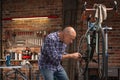 Man working on a bicycle indoors in a workshop Royalty Free Stock Photo