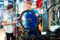 Man working with bicycles wheel and helping boy