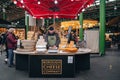 Man working at a Borough Cheese Company stall in Borough Market, London, UK