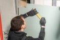 A man working Builder makes a marking on the drywall for electrical wiring. Metal drywall construction in a house during Royalty Free Stock Photo