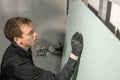 A man working Builder makes a marking on the drywall for electrical wiring. Metal drywall construction in a house during Royalty Free Stock Photo