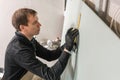 A man working Builder makes a marking on the drywall for electrical wiring. Metal drywall construction in a house during Royalty Free Stock Photo