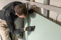 A man working Builder makes a marking on the drywall for electrical wiring. Metal drywall construction in a house during Royalty Free Stock Photo
