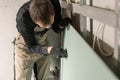 A man working Builder makes a marking on the drywall for electrical wiring. Metal drywall construction in a house during Royalty Free Stock Photo