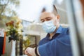 Man working from a cafe checking time on his watch and drinking coffee. Businessman wearing sterile medical mask leading matters Royalty Free Stock Photo