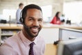 Man working in a call centre smiling to camera, close-up